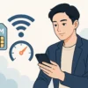 格安SIMの通信速度や安定性を調べている日本人男性が、スマートフォンを操作しているイラスト。背景にはSIMカード、Wi-Fi、速度メーターのアイコンが描かれている。現代的で清潔感のあるスタイル。