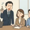 会議で自分の意見を強く押し通そうとする男性社員と、困惑した表情で聞いている同僚の日本人会社員を描いたイラスト